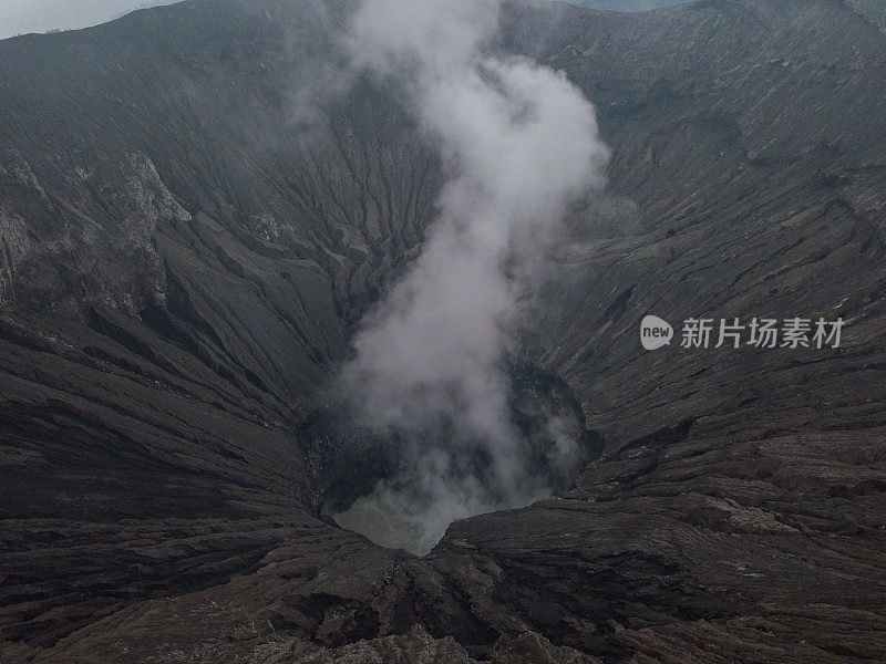 无人机鸟瞰图的Bromo火山口边缘与蒸汽在Bromo山国家公园在Cemoro Lawang村-东爪哇，印度尼西亚，亚洲。旅游目的地冒险的自然概念